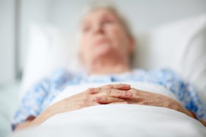 Close-up of hands of senior woman lying in hospital ward