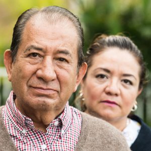 Caring, hispanic nurse and elderly senior patient in nursing home