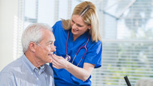 hospice nurse treating hospice patient with a tube 