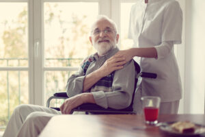 patient in wheelchair holding hospice nurse hand