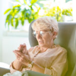elderly woman looking at hands
