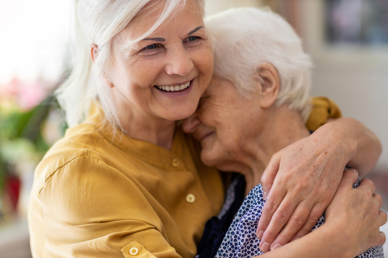 Woman hugging her elderly mother