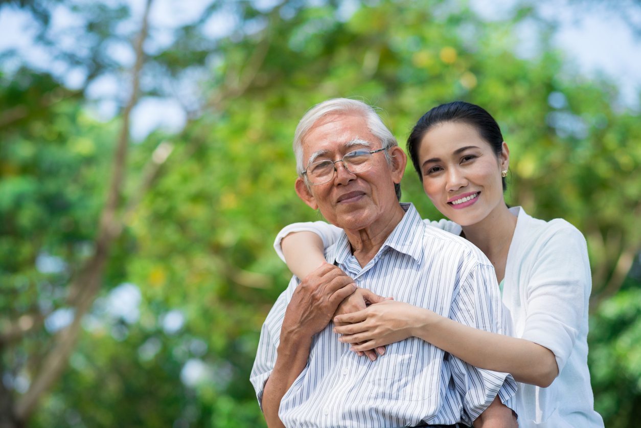 smiling Vietnamese woman hugging her father
