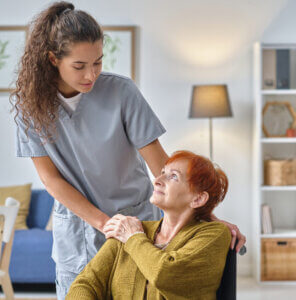 Nurse caring about senior woman in wheelchair