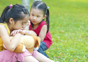 Little girl, east Asian, is comforting her crying sister