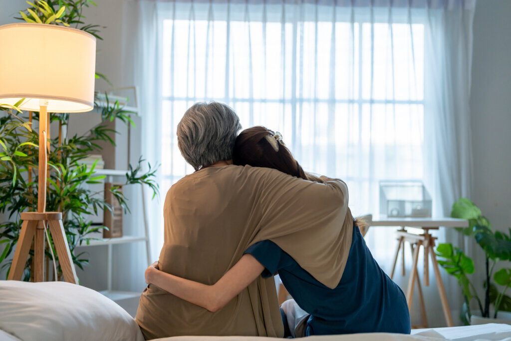 elderly mother and child hugging and comforting one another