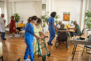 nurse helping a woman using a walker