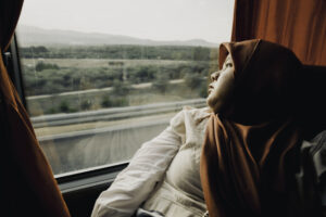 Woman wearing hijab looking out the window while traveling