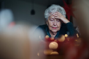 Elderly woman holding her head in grief