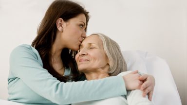 adult daughter hugging elderly mother