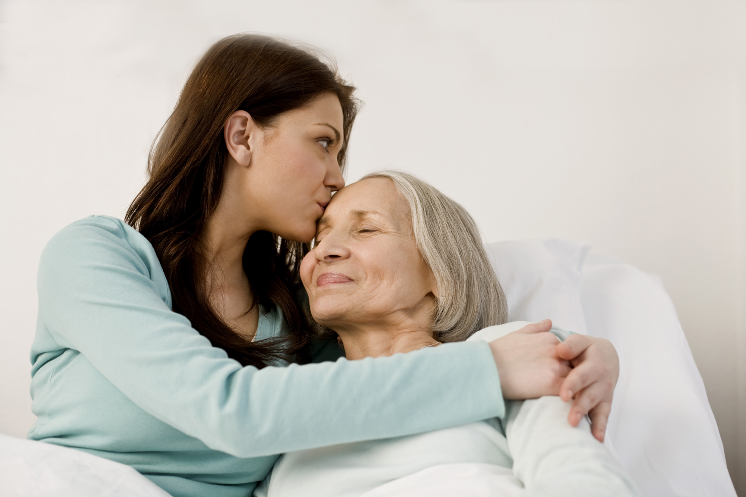 adult daughter hugging elderly mother