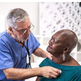 doctor using a stethoscope to listen to the heartbeat of the elderly