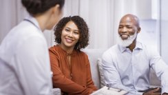 Smiling father and daughter with female doctor