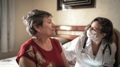Health visitor talking to a senior woman during home visit