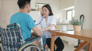 Home Care Worker Lwith Patient in Wheel Chair
