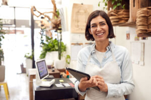 Female Business Owner With Digital Tablet Behind Desk
