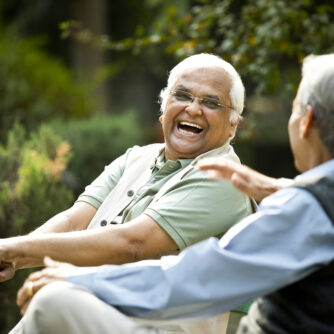 Two senior men discussing on park bench