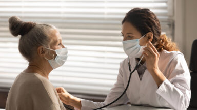 Female doctor listen to senior patient heart