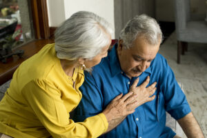 Wife comforting her husband suffering with severe chest pain