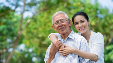 smiling Vietnamese woman hugging her father