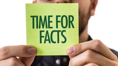 man holding note that states "time for facts"