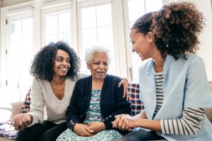 two daughters embracing mom on couch