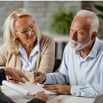 senior couple signing a contract while having a meeting with agent