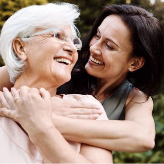 adult daughter hugging her elderly mother